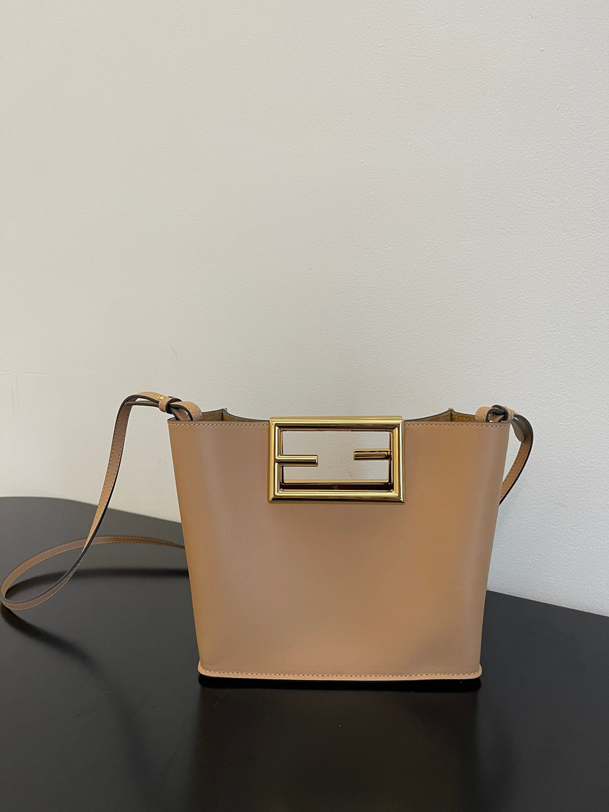 Tan Leather Bucket Bag with Gold Geometric Clasp and Shoulder Strap